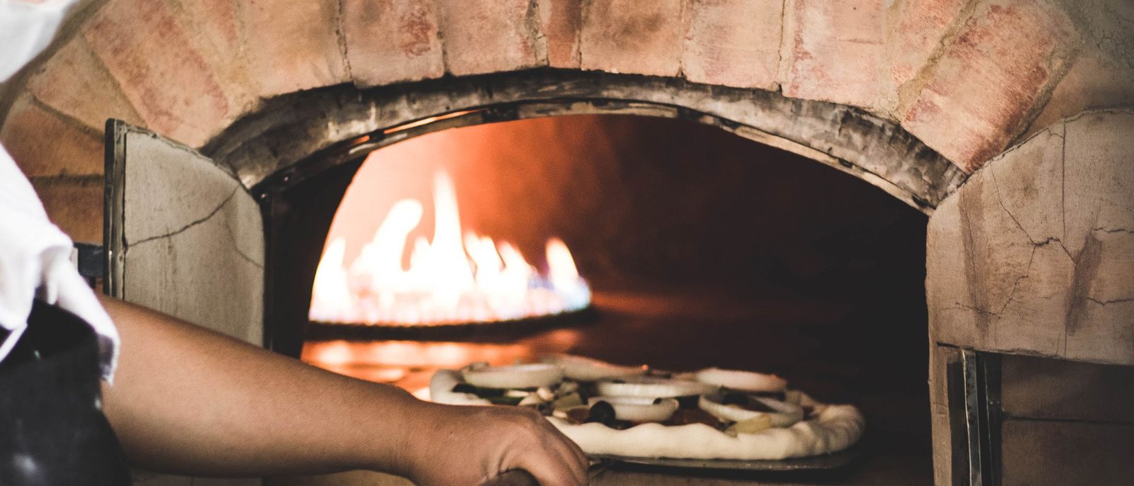 La bocca del forno a legna con la fiamma viva